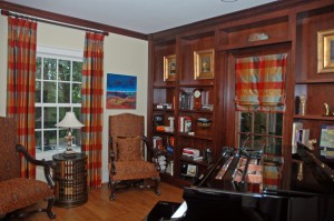 This is a room where the windows are very different and require different treatments. We have chosen to do keep both styles simple, but to have the unifying detail of covered buttons. The drapery and shade are lined and interlined in a plaid silk. The shade is functional.