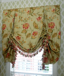 This powder room packs a huge punch with the lattice wall paper and this gorgeous floral London Shade. The tassel trim highlights the burnt red and gold colors in the fabric.