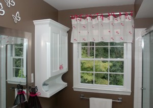 This valence has been re-purposed from a shower curtain valence to a fun fushia grossgrain ribbon tied window valence. The embroidered pink flowers stand out against the white linen and chocolate brown walls.