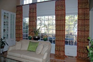 These draperies are 1-1/4 widths each panel with tassel trim along both edges in the center two panels. They are installed just below the second story windows to keep with the scale of the room.