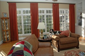 This is a family room where everyone kicks back and relaxes. Even the family dog has a place to call her own. These draperies help solidify the room by framing the windows and the gorgeous view outside.