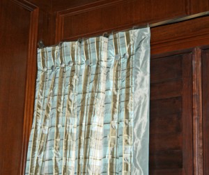This exquisite drapery is all about the details which include inverted boxed pleats, silk covered buttons & for the leading edge there is a 3" silk banding. All this mounted on a narrow twisted bronze rod from Antique Drapery Hardware Company.