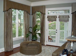 The sitting area of the master suite had surround walls of windows. The window shown had intense morning sunshine so the draperies were lined and interlined. For the French Doors we created Roman Shades with a small valence at the top.