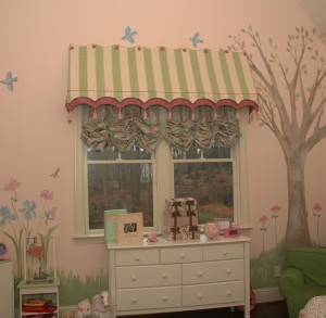 This awning valence perfectly complements the playful mural in this little girls room. There is button & micro-cording detailing along the top of the treatment with little scallops along the bottom edge. There is a double layer of scallops with a three colored tassel hanging from each point.